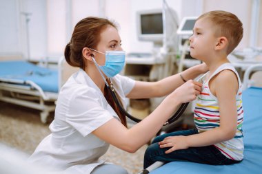 Professional general pediatrician in a white dress listen to the sound of the lungs and heart of anpatient with a stethoscope. hild's health.