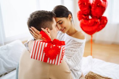 Hediye değişimi. Evde Sevgililer Günü 'nü kutlayan genç bir çift. Birlikte romantik bir gün..