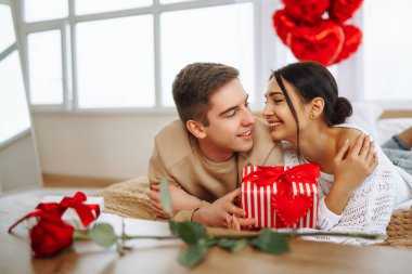 Hediye değişimi. Evde Sevgililer Günü 'nü kutlayan genç bir çift. Birlikte romantik bir gün..