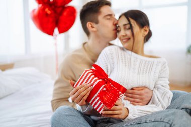 Hediye değişimi. Evde Sevgililer Günü 'nü kutlayan genç bir çift. Birlikte romantik bir gün..