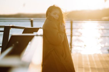 Beautiful woman on the pier. People, lifestyle, relaxation and vacations concept.