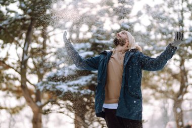 Young man in snowy winter forest. People, lifestyle, relaxation and vacations concept.