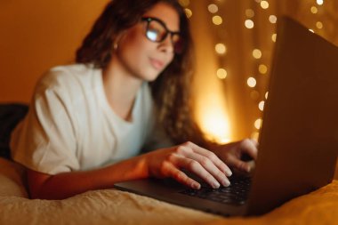 Young woman working online or studying sitting at home office, late at night. Business, blogging, freelance, Online shopping, education concept.