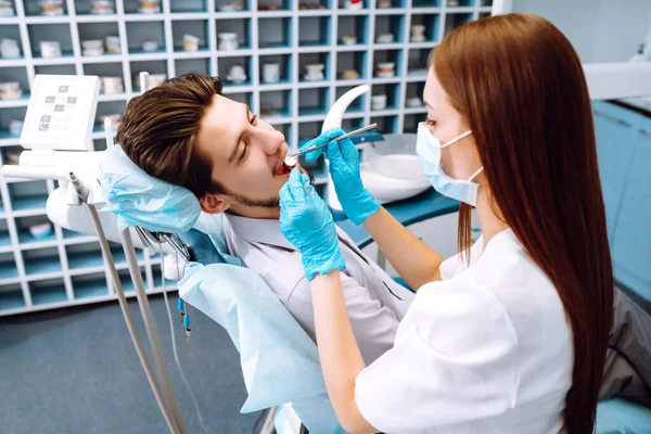 Man at the dentist's chair during a dental procedure. Overview of dental caries prevention.  Healthy teeth and medicine concept.