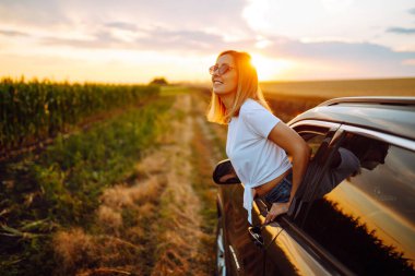 Towards adventure! Young woman is resting and enjoying the trip in the car. Lifestyle, travel, tourism, nature, active life.