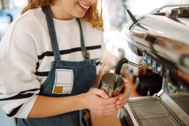 Female barista making coffee in a coffee machine. Food and drink concept.