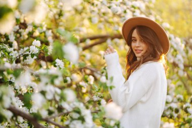 Young beautiful woman relaxing in blooming  garden. Spring,  romantic and lifestyle concept.