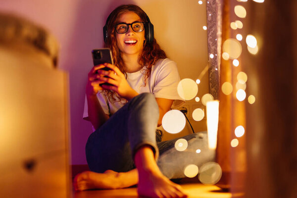 Молодая женщина в наушниках слушает музыку и болтает. Live, relax, технологическая концепция.