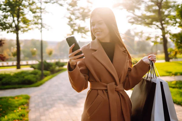 Glimlachende Vrouw Met Boodschappentassen Met Haar Telefoon Aankopen Zwarte Vrijdag — Stockfoto