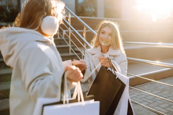 Alışveriş merkezinin yakınında torbaları olan şık bir anne ve küçük bir kız. Bir alışveriş, kara cuma, indirimler, satış konsepti..