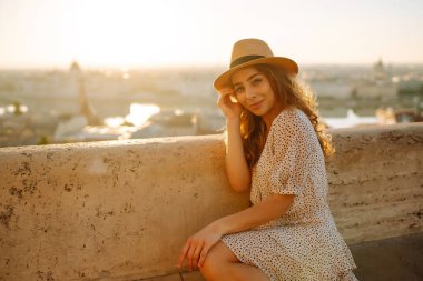 Gün batımında şehir merkezine bakan genç bir bayan turist. Seyahat ve turizm kavramı.