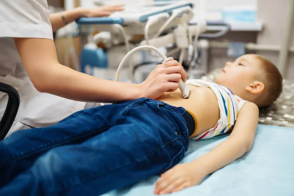 医師は 診療所で現代の医療機器を使用して 小さな男の子の心臓や腹部器官の超音波検査を行います 小児科と小児発達モニタリング — ストック写真