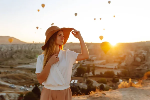 Young Woman Stands Mountain Flying Air Balloons Background Famous Tourist — Fotografie, imagine de stoc