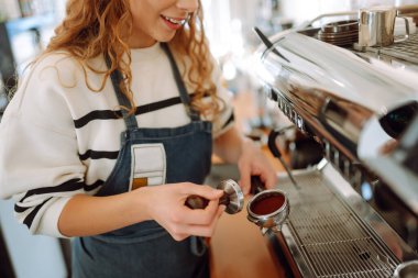 Kahve makinesinde kahve yapan bayan barista. İş ve hizmet kavramı. Paket yemek..