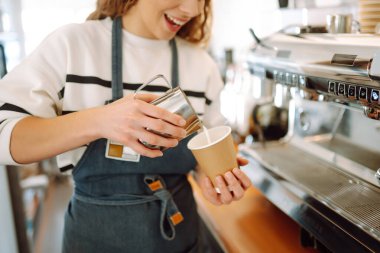 Kahve makinesinde kahve yapan bayan barista. İş ve hizmet kavramı. Paket yemek..