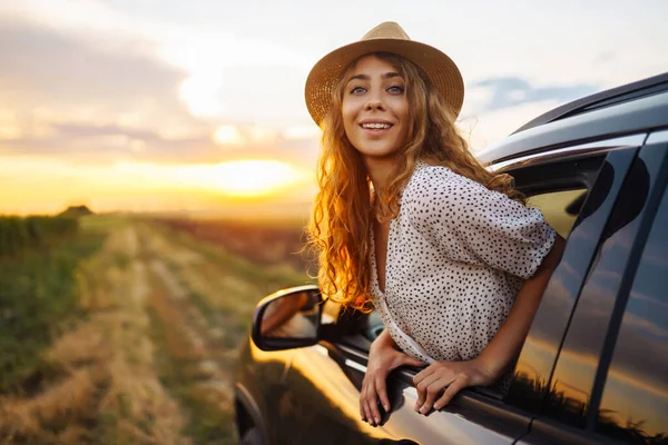Yaz tatili seyahatinde arabasının camından sarkan rahat mutlu kadın. Yaşam tarzı, seyahat, turizm, doğa, aktif yaşam.