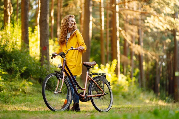 Jovem Mulher Feliz Casaco Amarelo Monta Uma Bicicleta Parque Ensolarado — Fotografia de Stock