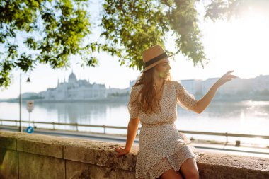 Genç, mutlu bir kadın setin önünde poz veriyor ve fotoğraf çekiyor. Güzel bir kadın güzel bir setten hoşlanır. Turizm, rahatlama, gençlik ve doğa kavramı.