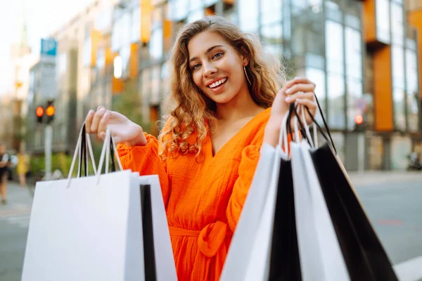 快乐的女人 带着购物袋走在阳光灿烂的街上 生活方式 消费主义的概念 — 图库照片