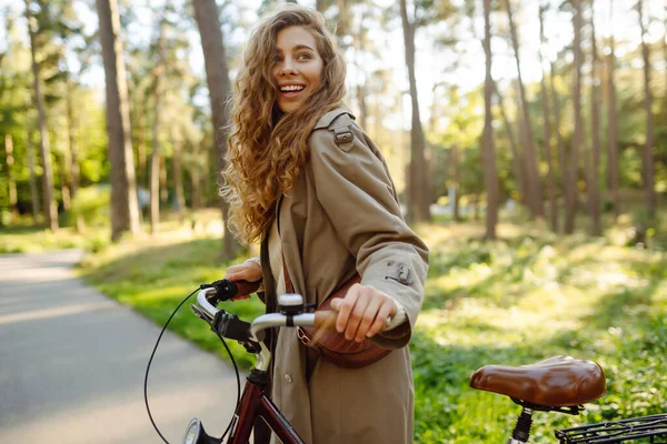 Mujer Sonriente Con Pelo Rizado Abrigo Monta Una Bicicleta Parque — Foto de Stock