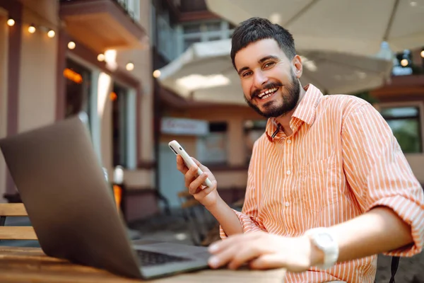 Jovem Sorridente Trabalhando Café Rua Com Laptop Telefone Conceito Negócio — Fotografia de Stock