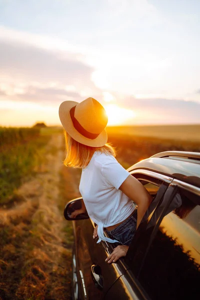 生活方式 快乐的女人从车窗欣赏日落美景 年轻的女游客休息 从车窗向外倾斜 享受旅行的乐趣 旅行概念 走向冒险 — 图库照片