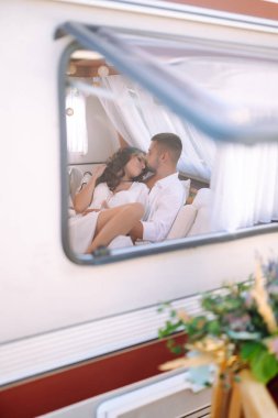 Yeni yapılmış çift bir karavanda dinleniyor. Yeni evliler şefkatle kucaklaşır, bir minibüste eğlenirler, karavanda kamp yaparlar. Birlikte. Düğün için. Romantik an.
