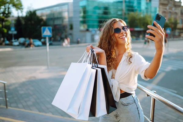 Stijlvolle Jonge Vrouw Winkelend Met Een Telefoon Een Zonnige Straat — Stockfoto