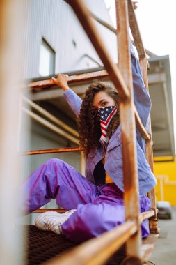 Amerikan bandanalı şık bir sokak dansçısı dans ediyor. Şık giyinmiş genç bir dansçı hareketleri gösterir. Dans ve spor konsepti.