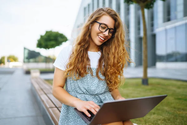 Glimlachende Jonge Vrouw Bril Met Draadloze Koptelefoon Een Laptop Die — Stockfoto