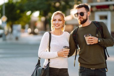 Genç ve mutlu bir çift birlikte vakit geçiriyorlar, kahve içiyorlar, sabah şehirde gezinirken eğleniyorlar. Gençlik, aşk, birlikte zaman geçirmek, yaşam tarzı..