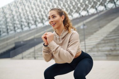 Aktif yaşam tarzı. Genç fitness kadını dışarıda egzersiz yapıyor ve esniyor. Formda bir kadın sağlığını sporla korur. Spor, spor eğitimi..