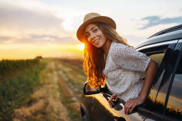 Młoda Szczęśliwa Kobieta Kapeluszu Lubi Jeździć Samochodem Wychylając Się Przez — Zdjęcie stockowe