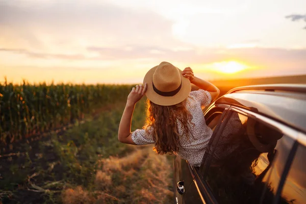 모자를 여자는 창밖으로 기울이며 차타는 즐긴다 여름에는 아름다운 여행사가 자동차를 — 스톡 사진
