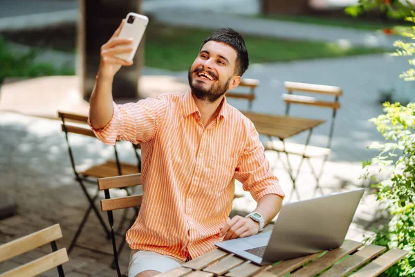 Freelancer Masculino Feliz Sorrindo Enquanto Trabalhava Laptop Com Telefone Conferência — Fotografia de Stock