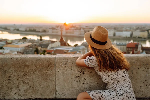 Şapkalı Güzel Kadın Şafak Vakti Şehrin Çarpıcı Manzarasının Tadını Çıkarıyor — Stok fotoğraf