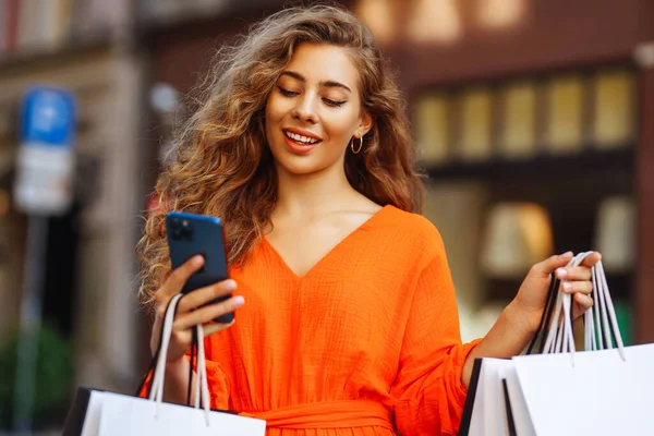 Winkelende Vrouw Jonge Vrouw Met Boodschappentassen Stad Met Telefoon Doet — Stockfoto
