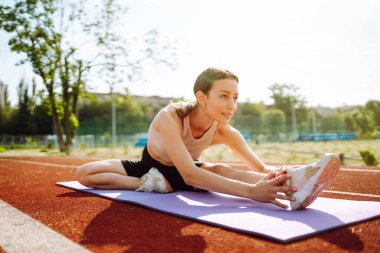 Spor kıyafetli genç bir kadın sabahları dışarıda egzersiz yapıyor. Spor, aktif yaşam, spor eğitimi, sağlıklı yaşam tarzı..