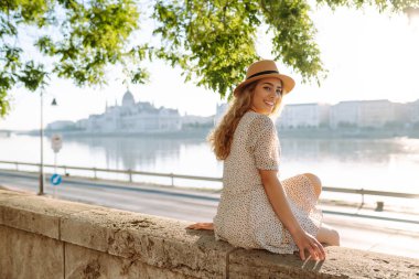 Genç bayan turist gün batımında şehir manzarasının tadını çıkarıyor. Avrupa gezisi. Seyahat, turizm ve aktif yaşam tarzı konsepti.