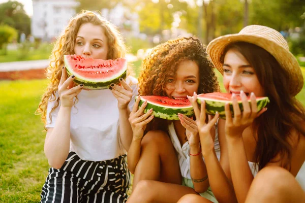 3人の美しい若い女の子が一緒に楽しみ 暑い日にスイカを食べています ライフスタイル 休暇のコンセプト — ストック写真