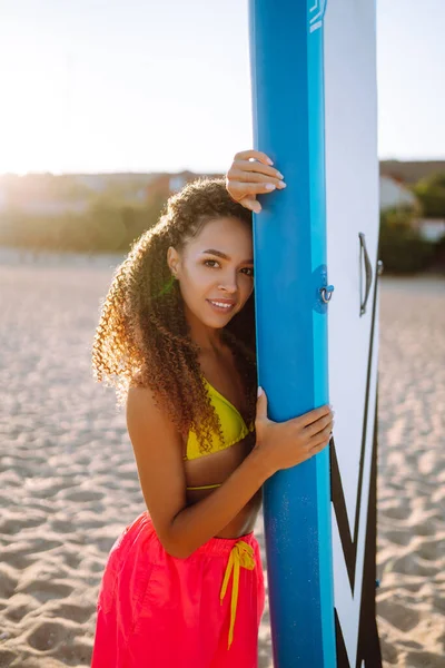 ビーチではグランダーを持つ若い女性 アクティブなライフスタイルとサーフィンの概念 スープボード — ストック写真
