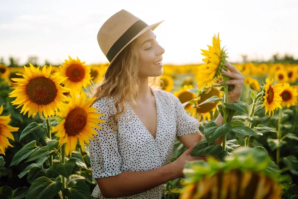 stock image Happy young woman surrounded by yellow sunflowers in full bloom, in a flower garden, traveling on holiday.