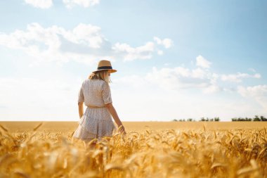 Tarlada doğanın tadını çıkaran şık bir kadın. Yaşam tarzı, seyahat, turizm, doğa, aktif yaşam.