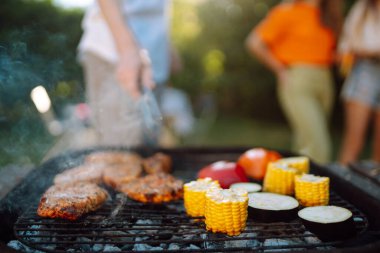 Izgara sebzeli ızgara ızgara et. Arkadaşlar et pişirir, eğlenir, rahatlar. Yaşam tarzı, tatiller, hafta sonları hariç.. 
