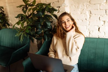 Kafede dizüstü bilgisayarı olan genç bir kadın. İş, blog yazma, serbest yazarlık, eğitim kavramı.