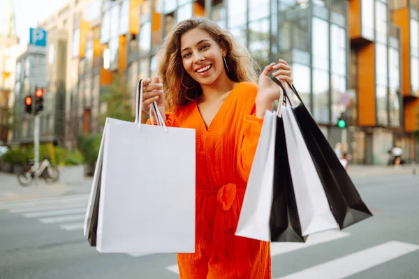 Alışveriş Torbalarıyla Caddede Yürüyen Neşeli Genç Bir Kadın Satın Almalar — Stok fotoğraf