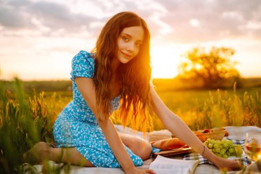 Genç bir kadın yaz günü parkta piknik yapıyor. Sağlıklı yiyecekler. Taze meyve. İnsanlar, yaşam tarzı, seyahat, doğa ve tatil kavramı.