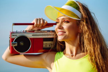 Sahilde dans etmek. Renkli mayo giymiş genç bir kadın sabah dans ediyor. Spor, spor, aerobik dışında. Aktif spor.