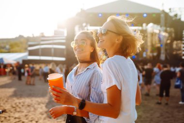Mutlu kız arkadaşlar müzik festivalinde eğleniyor. Yaz tatili, tatil konsepti. Arkadaşlık ve kutlama konsepti.