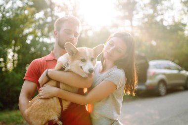 Sevgili evcil hayvanlarıyla yürüyüşe çıkmış genç bir çift. Evcil köpek kavramı. Aktif yaşam tarzı kavramı, seyahat, hafta sonu, rahatlama.